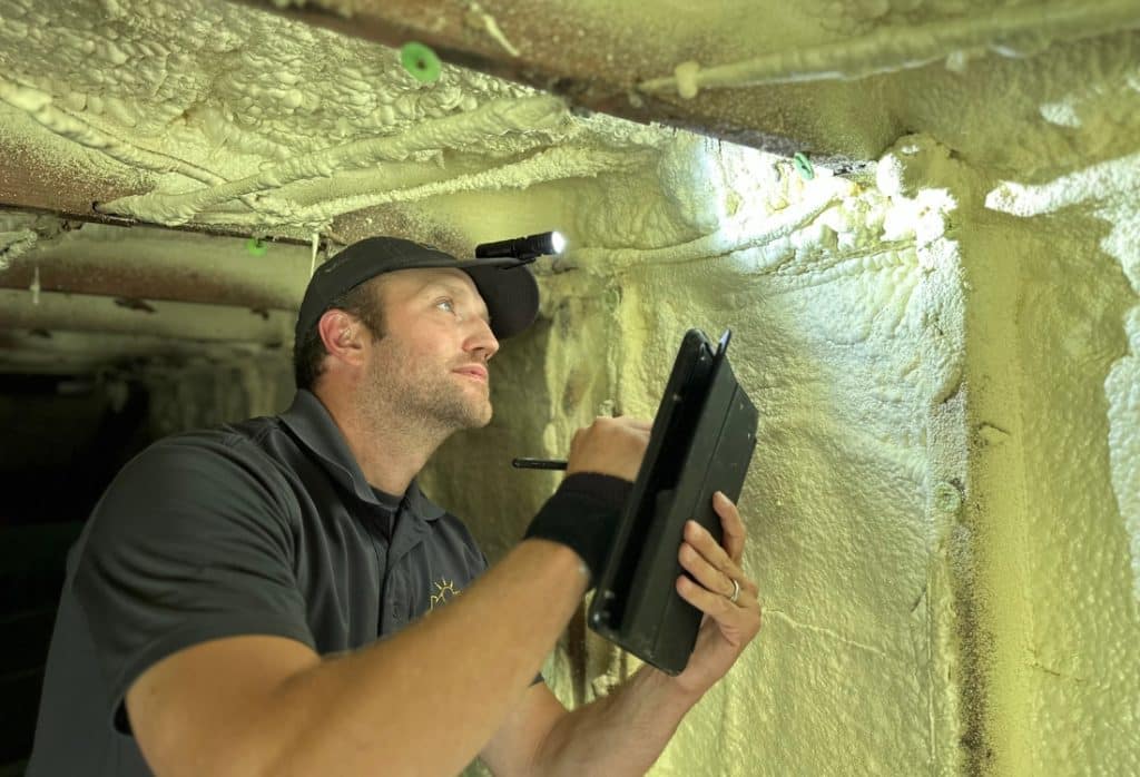 Foundation inspector documenting findings on a tablet during a home inspection in Jacksonville, FL.