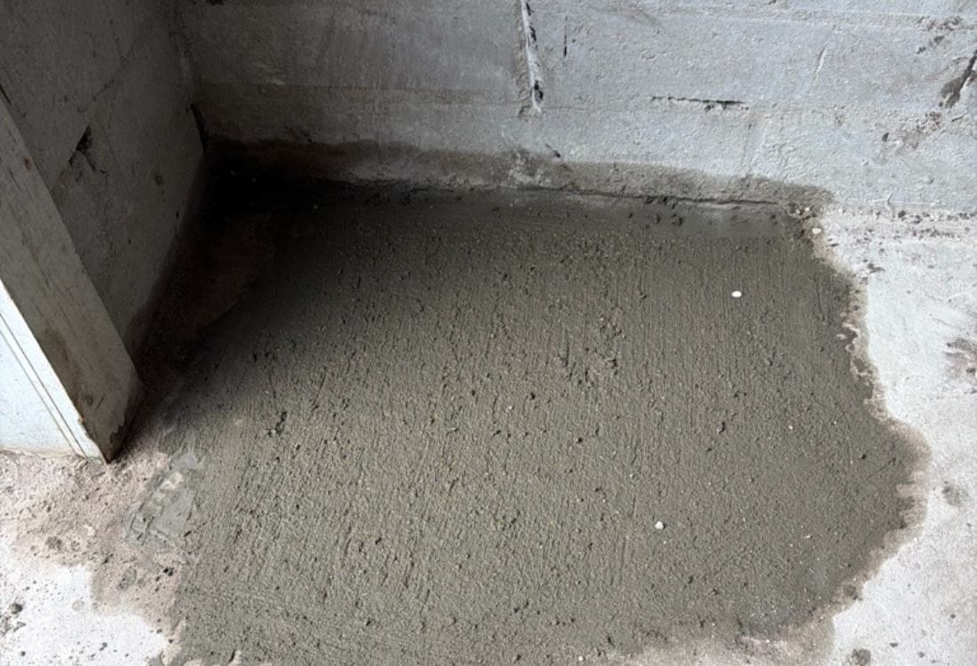 Laundry room floor patched with fresh concrete after helical pier installation in Neptune Beach, FL.