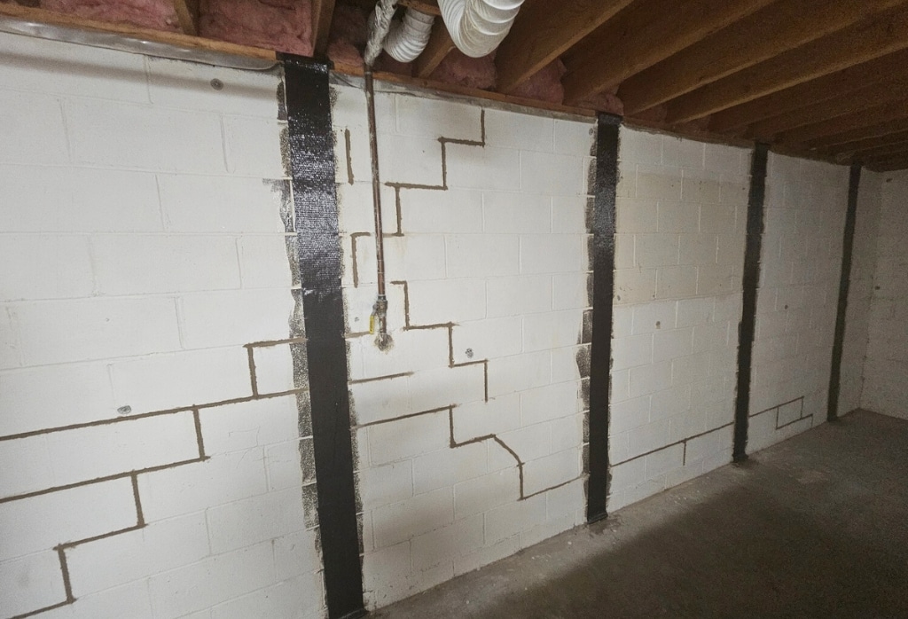 Installed carbon fiber straps on a home wall to stabilize foundation, a bowed foundation wall repair method in Jacksonville FL.