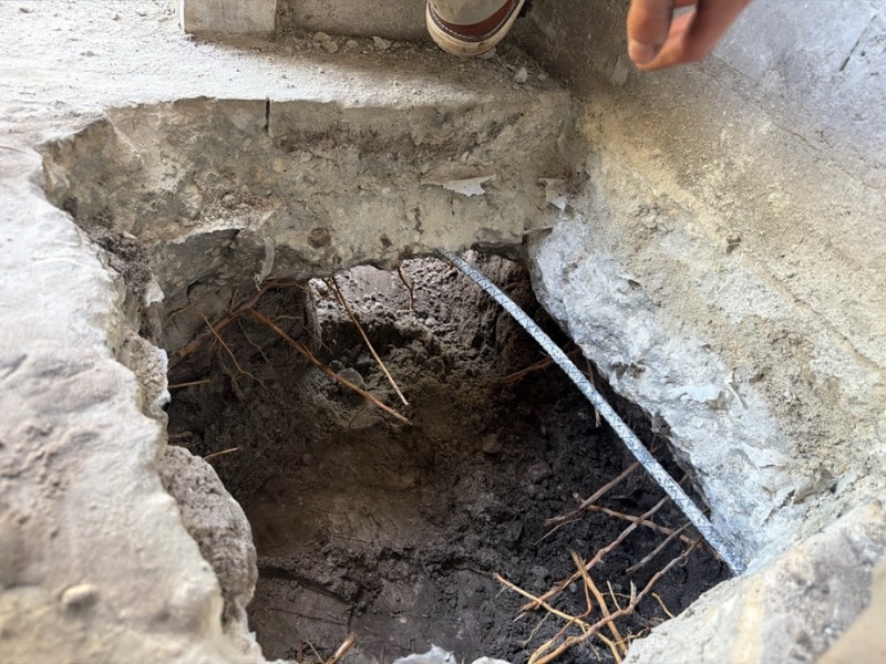 Cut laundry room concrete floor to access foundation footing during helical pier installation in Neptune Beach, FL.