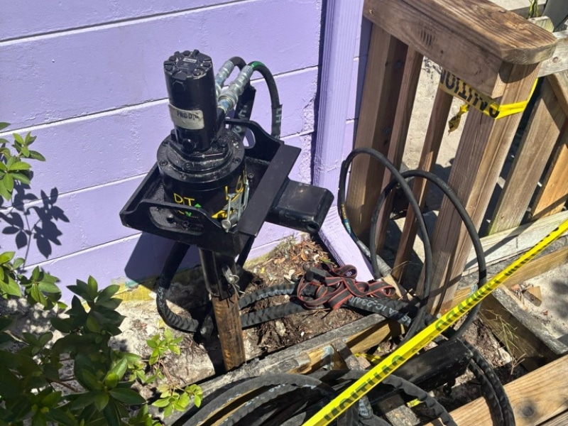 Hydraulic torque motor set up to drive helical piers into the ground during foundation repair in Neptune Beach, FL.