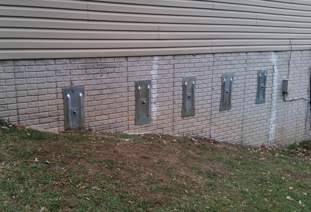 Wall anchors installed on a home foundation to pull the wall back, a bowed foundation wall repair method in Gainesville, FL.
