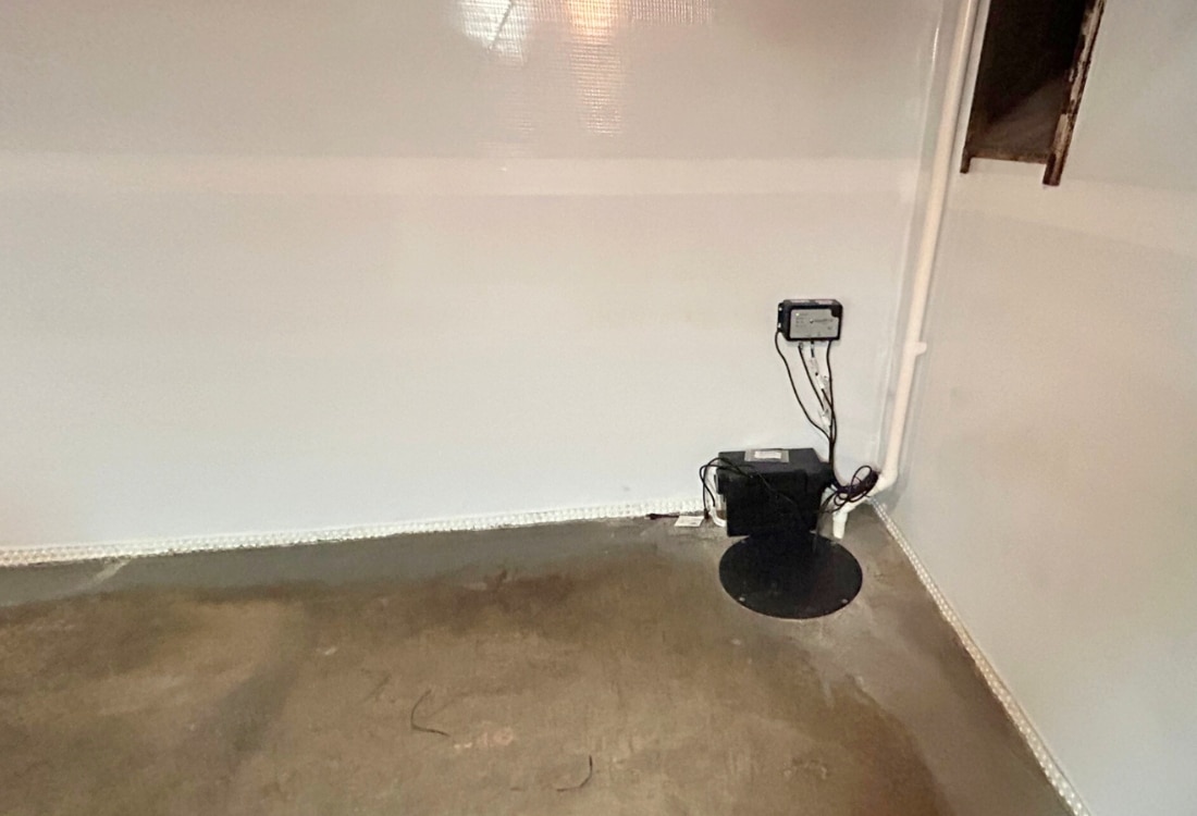 Basement sump pump installed near a foundation wall to collect and remove water, a foundation waterproofing method in St. Augustine, FL.