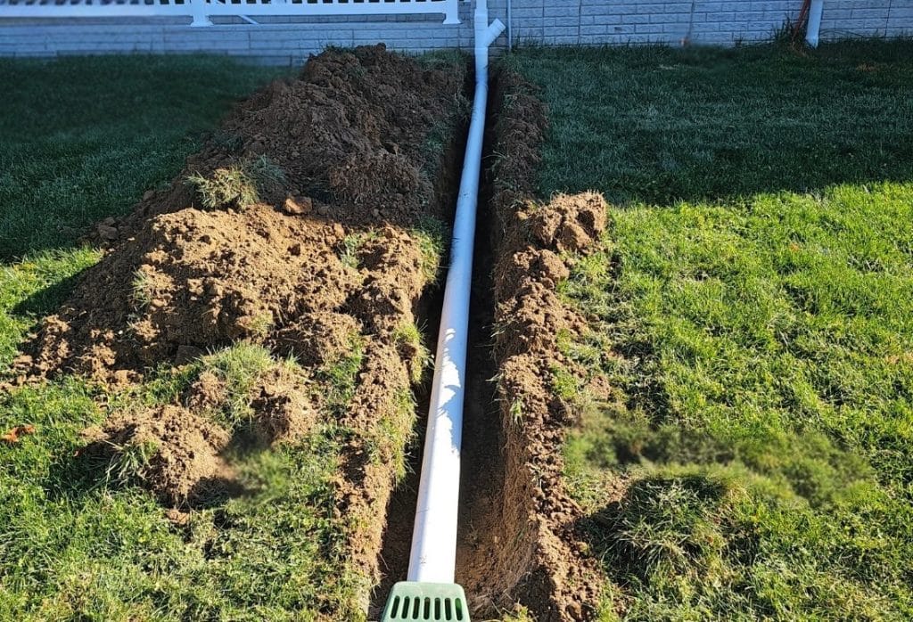 Properly installed downspout extension directing water away to stop water pooling around home foundation in St Augustine, FL.