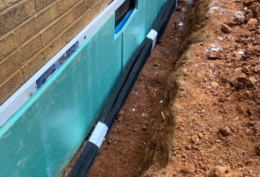 Exterior foundation waterproofing in progress, showing one of the methods used to protect home from water intrusion in Palm Coast, FL.