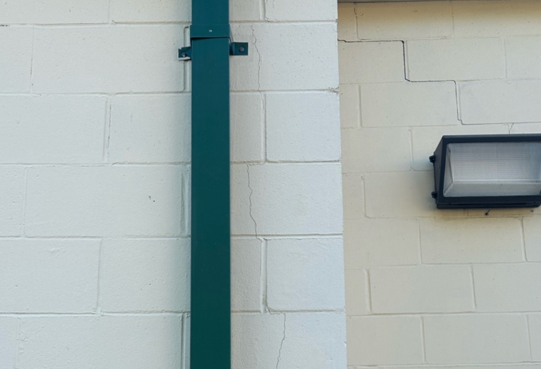 Stair-step crack running diagonally across CMU block courses from roofline needing commercial foundation repair in Jacksonville, FL.