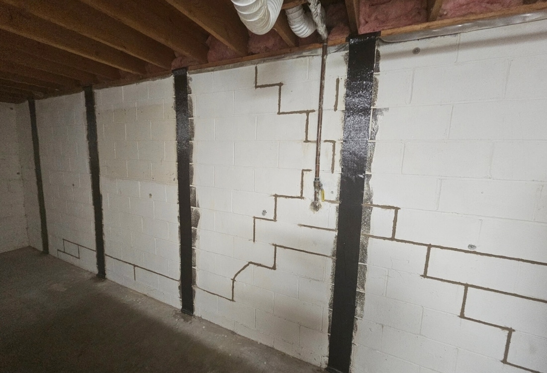 Carbon fiber straps installed on foundation wall with stair-step cracks to prevent movement and fix foundation cracks in Ocala, FL.