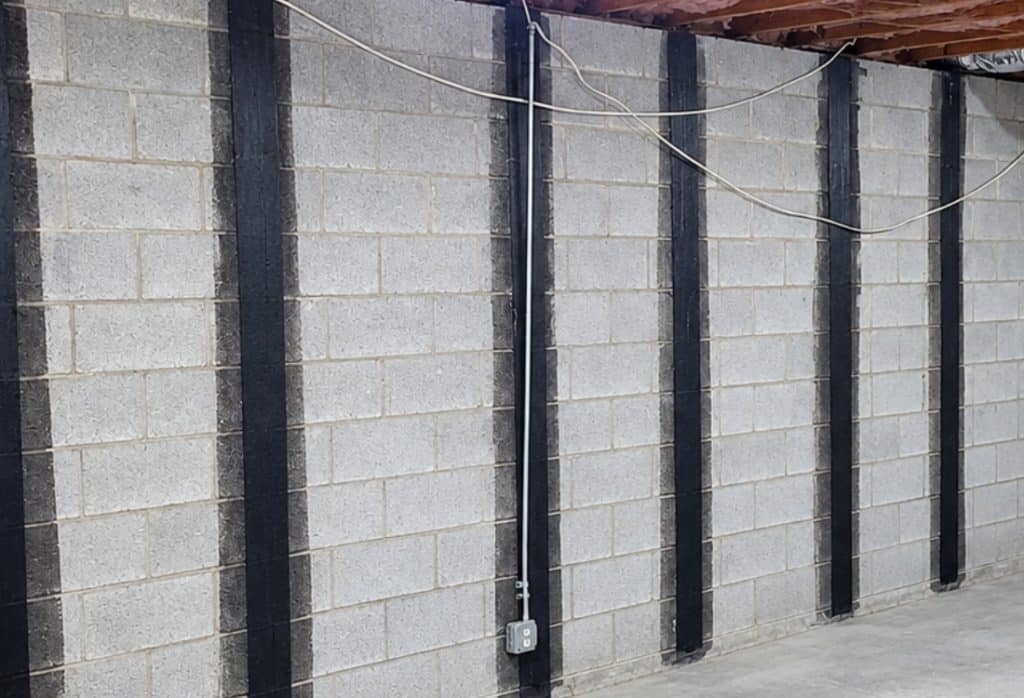 Multiple carbon fiber straps installed in wide walls, showing wall size affects carbon fiber foundation repair cost in Jacksonville, FL.