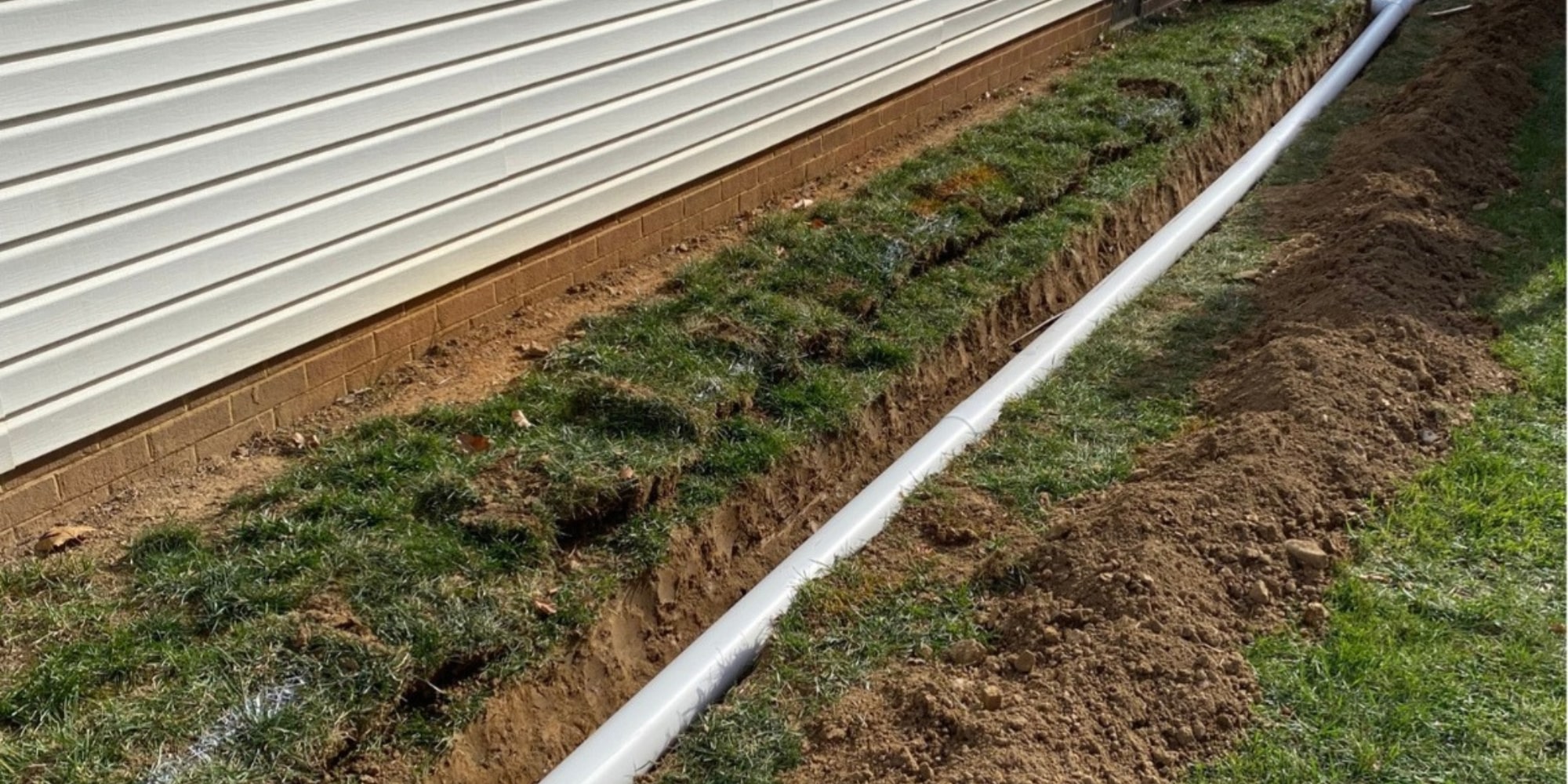 French drain trench with gravel and perforated pipe installed to protect Northern Florida home's foundation.